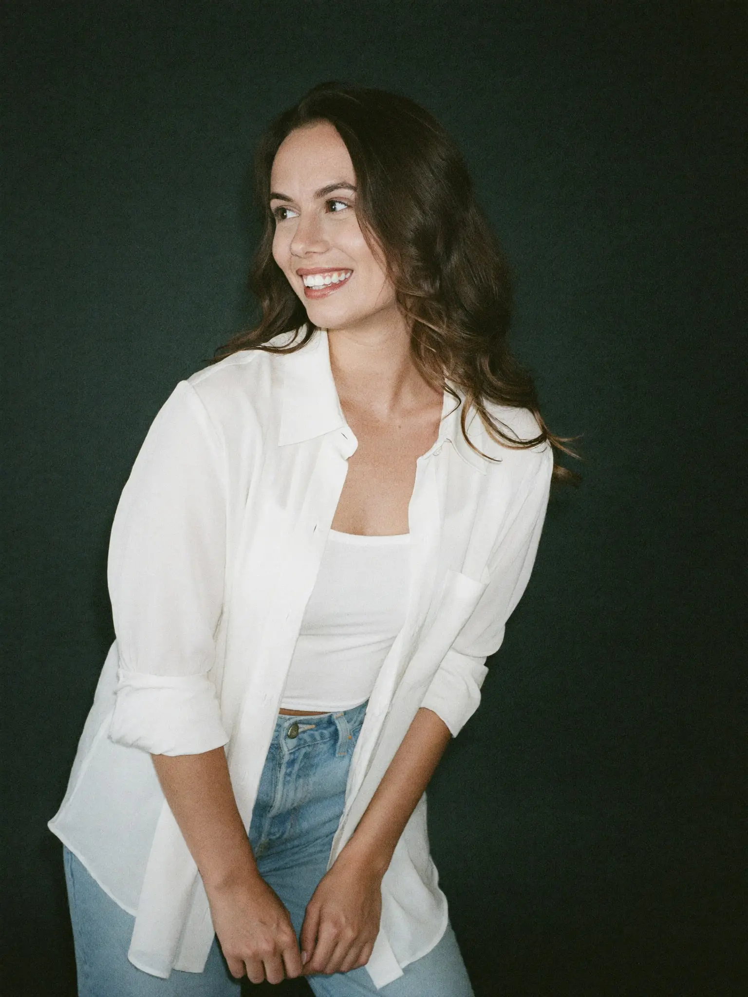 Paige Pope laughing and looking off to one side in a white shirt